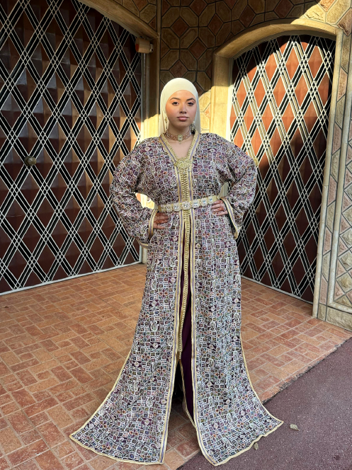 Caftan marocain traditionnel aux motifs cristallisés multicolores, rehaussé de détails dorés et d’une ceinture dorée.