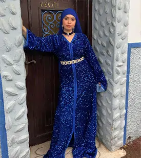 Caftan bleu roi brillant, orné de sequins scintillants, avec manches larges et ceinture argentée.